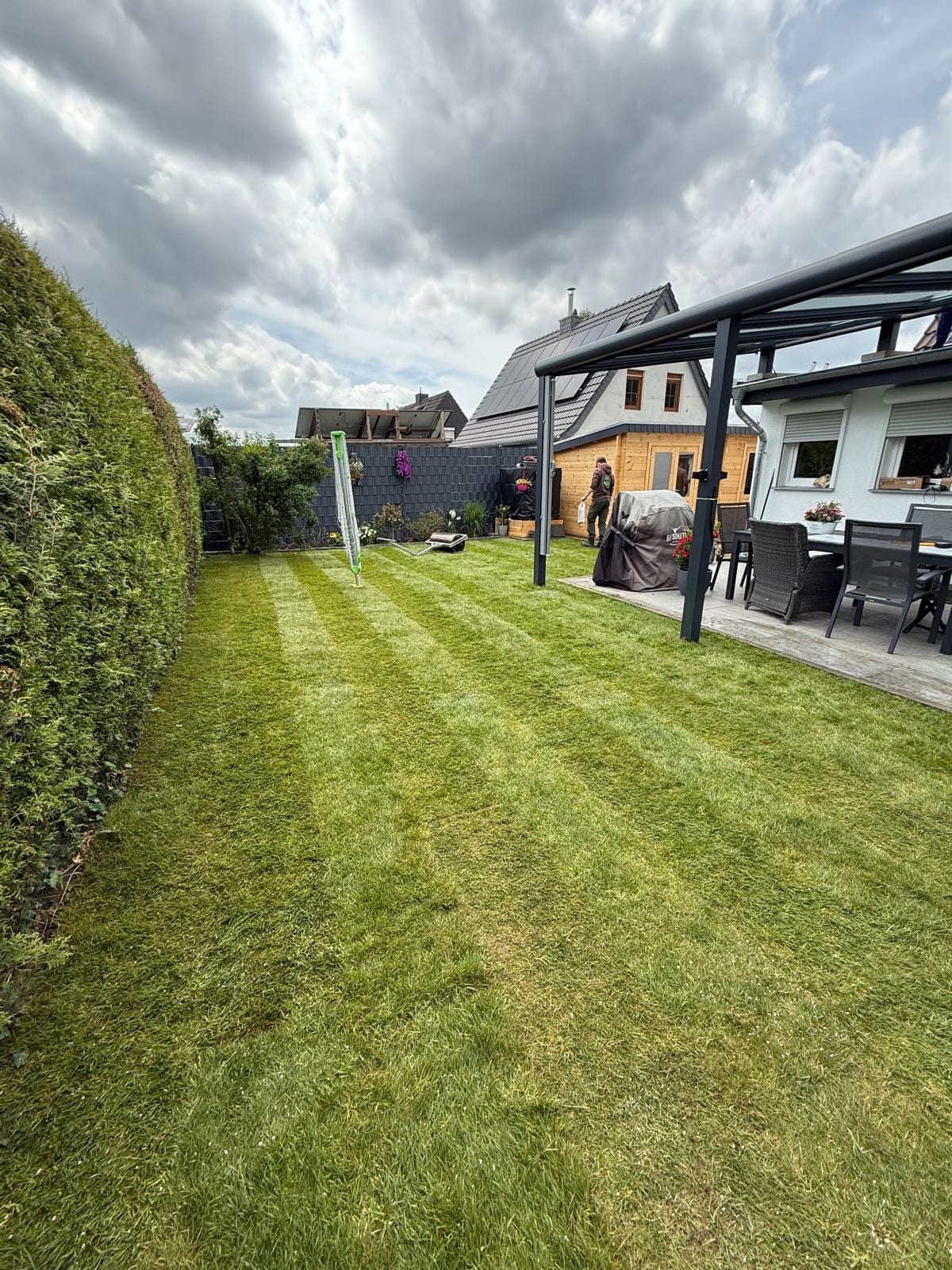 Derselbe Garten mit frisch verlegtem Rollrasen und Mähstreifen