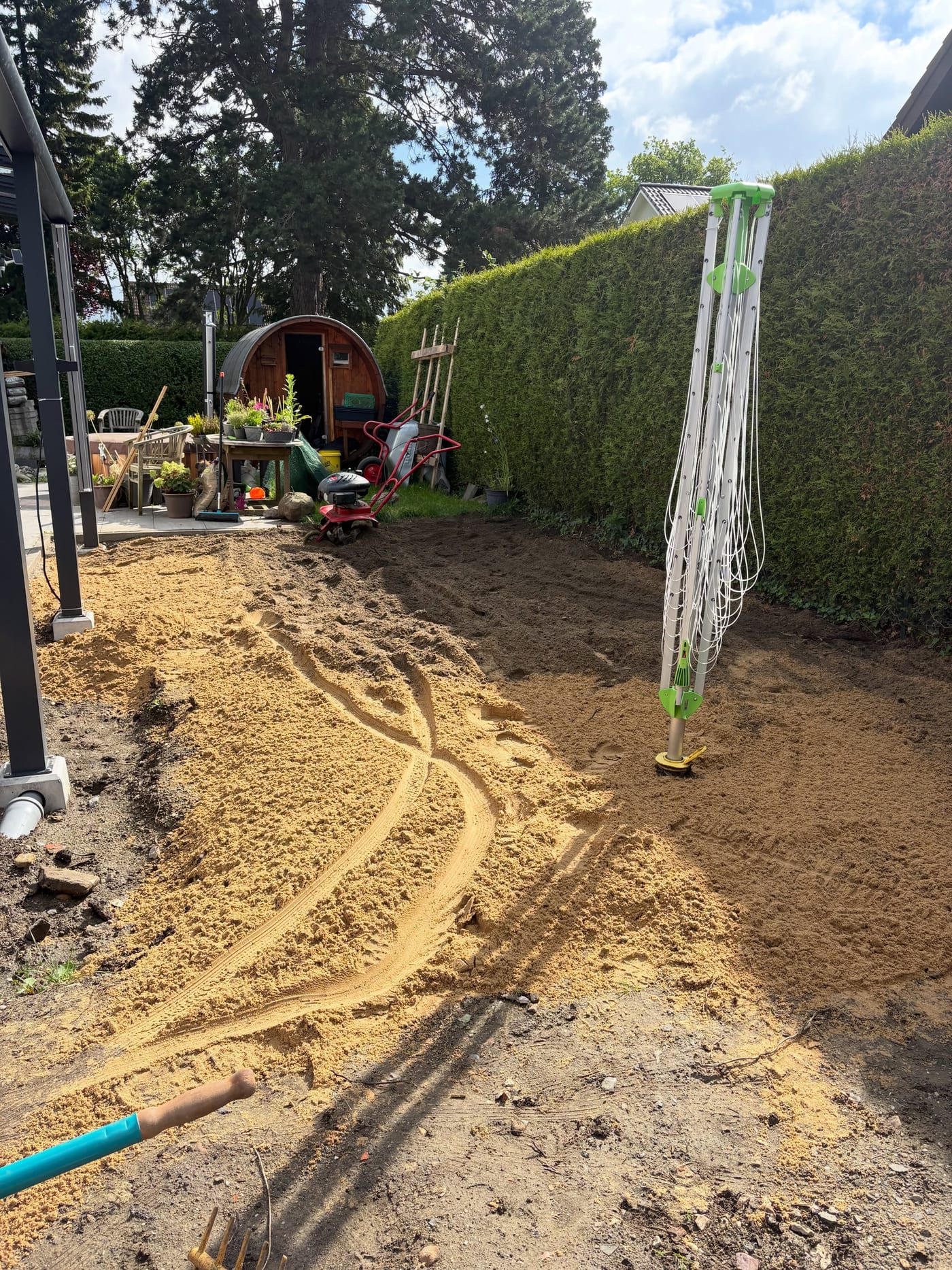 Sand wird in den Gartenboden eingefräst