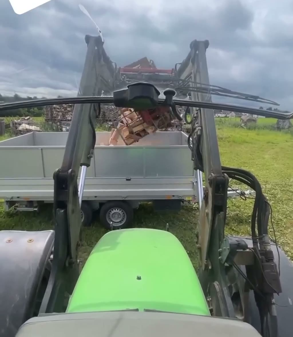 Traktor mit beladenem Brennholz-Anhänger